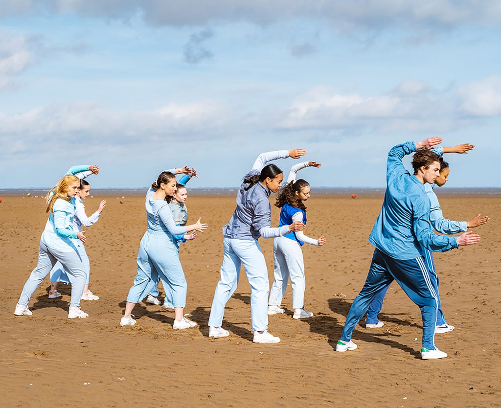 Some people practicing a dance on a beach