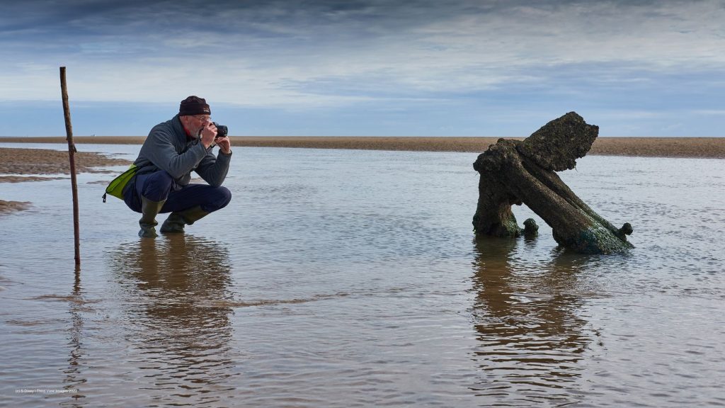 Man taking photo of coastal feature